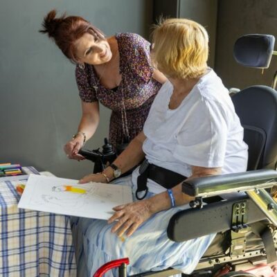 A support worker drawing alongside a participant in her wheelchair